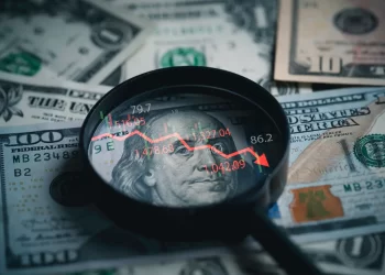 Stock image of cash and a magnifying glass