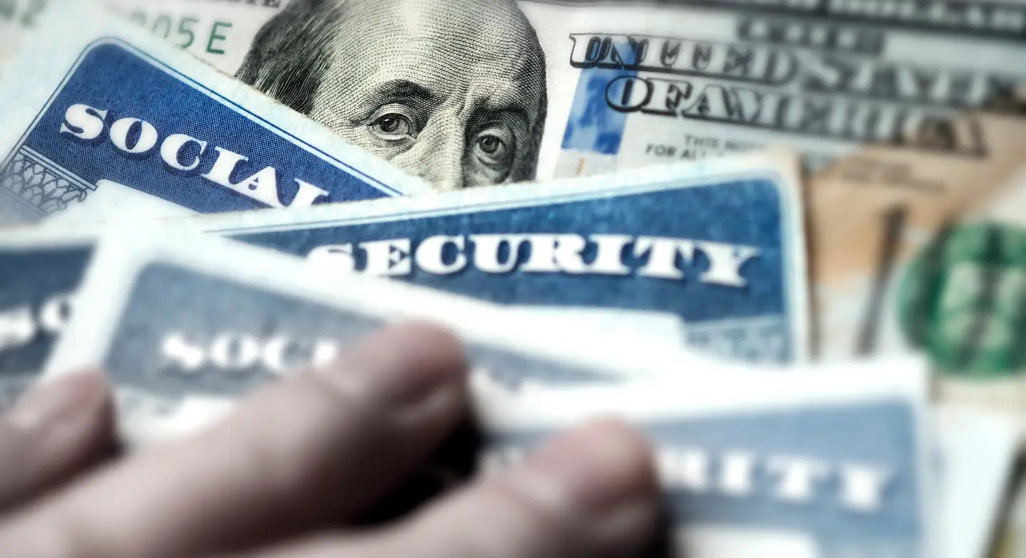 Stock image of social security cards and cash, symbolizing social security payments